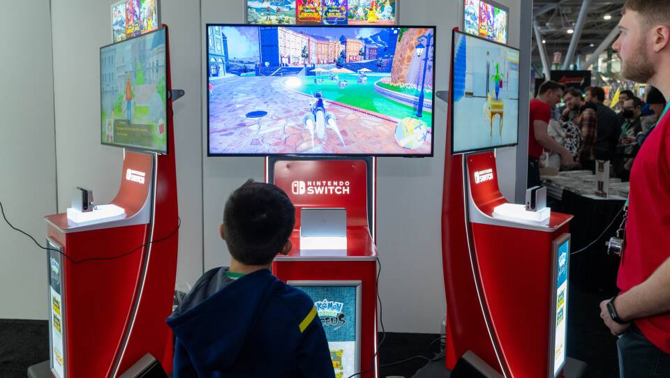 A boy looks up at a video game screen.