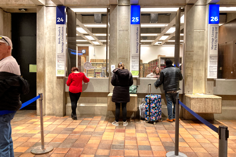 A few people in coats stand at city service windows