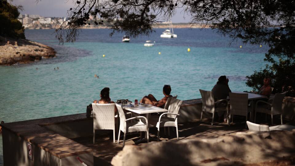 The European Union has decided on its first list of approved travel partners, as part of its reopening of external borders. Here, people sit in a terrace bar at the beach in Palma de Mallorca, Spain, earlier this month, when many internal travel restrictions were lifted.