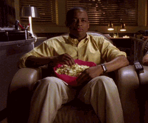 A man grooves while eating popcorn
