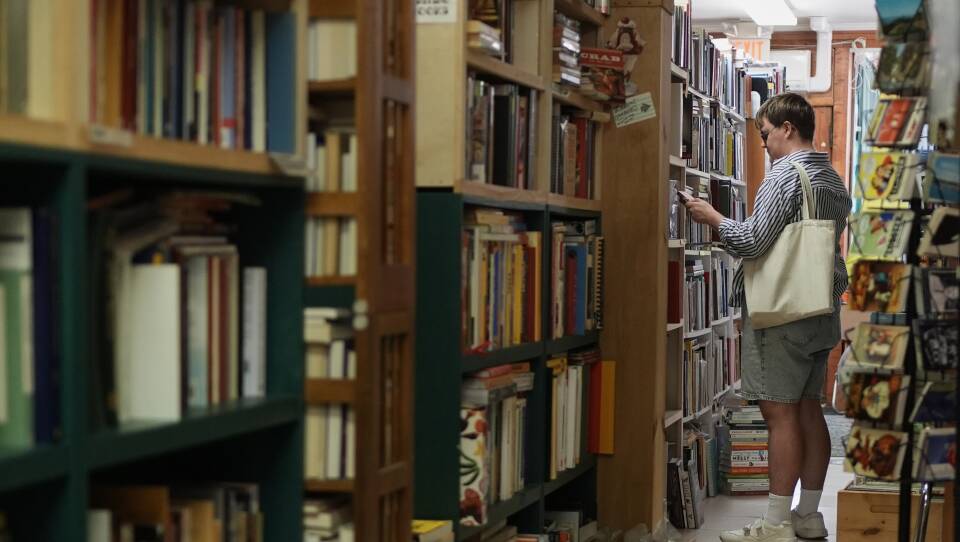 A person browses bookshelves.