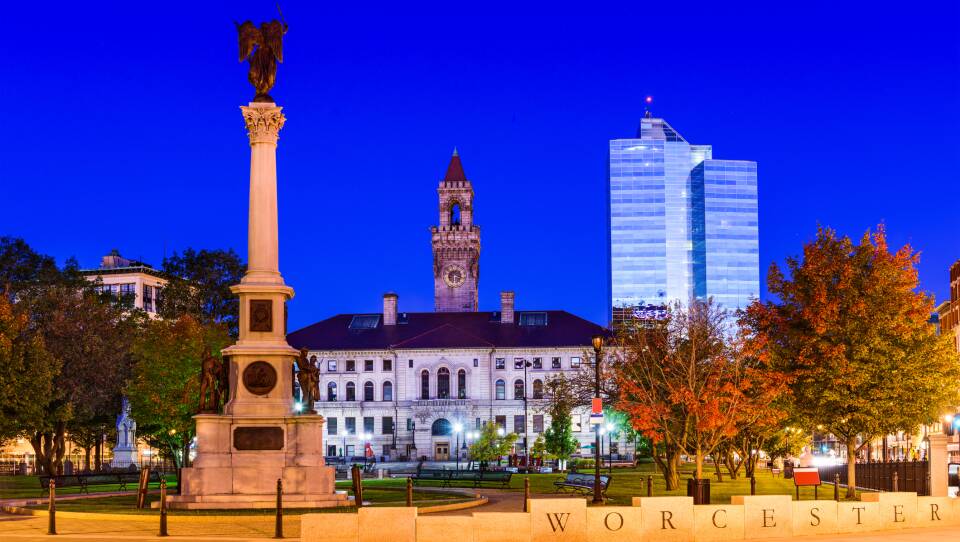 The dark blue night sky hangs over Worcester Commons and City Hall during autumn.