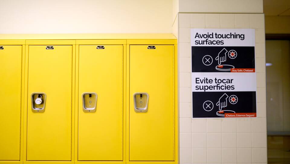 Yellow student lockers with a sign asking students to not touch surfaces