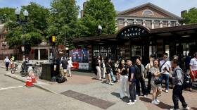 Crowds standing along busy street in Harvard Square in Cambridge