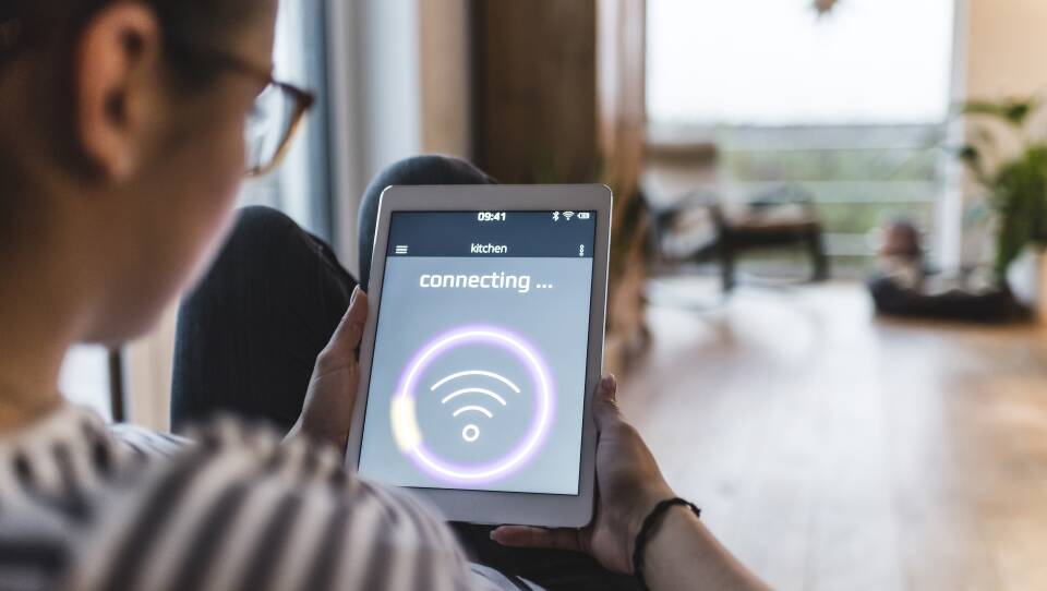 Woman using tablet with wifi symbol at home