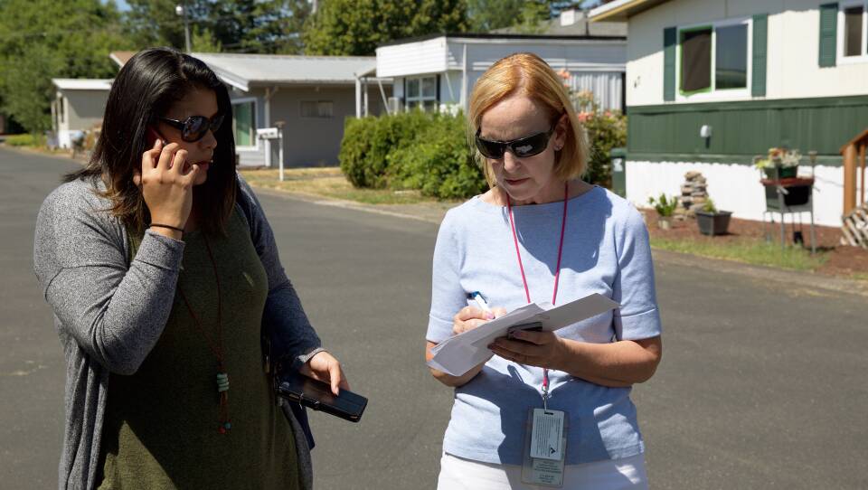 Mary Horman (left), a registered nurse for Clackamas County, and Liz Baca, a disease intervention specialist for the county, search for the right address in an Oregon neighborhood. Part of their job is to get information to people who may have a serious, treatable infection, yet not realize it.