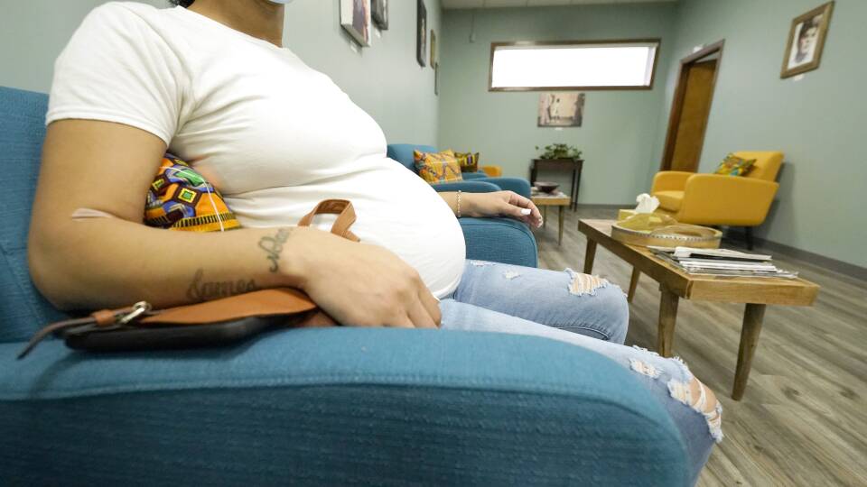 A pregnant woman sits in a waiting room.