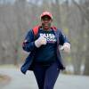 Tiffany runs through a wooded park wearing mittens and a shirt that reads 'Push: Black Girls Run!'
