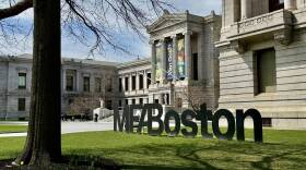 Exterior view of large museum building with sign in foreground that reads M-F-A Boston.