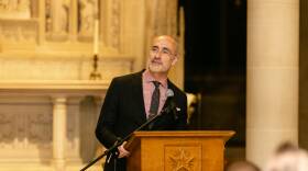 Arthur Brooks stands at a podium in front of a microphone
