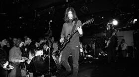 A black and white photo of a ban performing on stage.