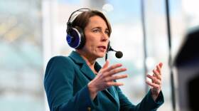 A woman in a blazer speaks into a radio headset