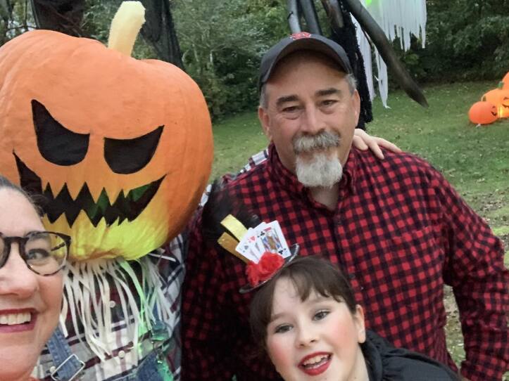 In this family selfie, Jennifer McNally Monac poses with son Coleman (in pumpkin head costume), daughter Elizabeth, and husband Ben Monac, who created many of the Halloween creatures in the family display.