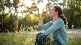 Woman sitting outdoors and suffering from pollen allergy