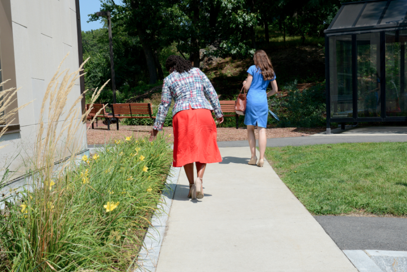 Ayanna Pressley runs her hand along a flower bed in front of Leventhal House.