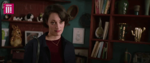 A woman makes eye contact with the camera and nods