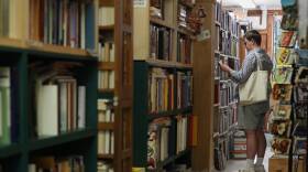 A person browses bookshelves.