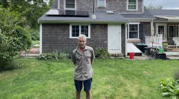  John Beach, 74, stands in his backyard in Yarmouth, where he can see newly installed solar panels. 