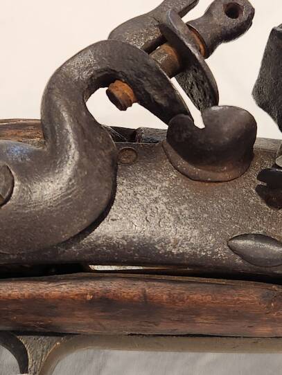 A close up view of the firing mechanism on an old flintlock musket.
