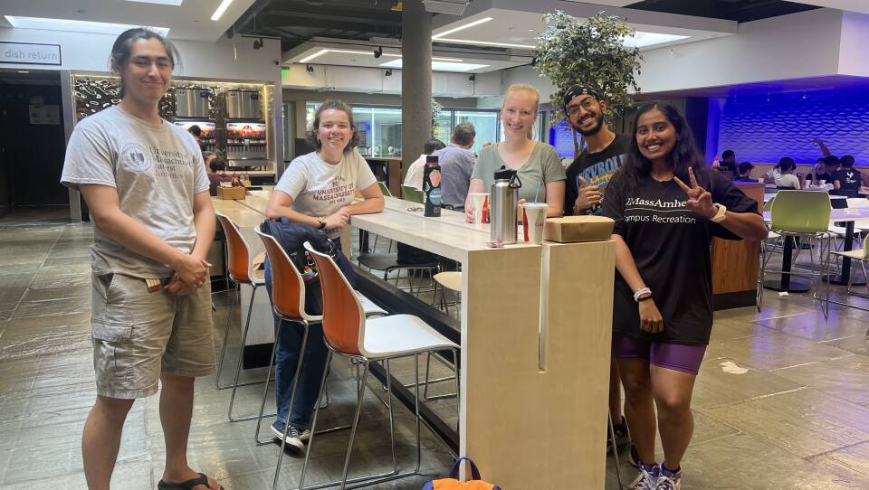 UMass Amherst students (from keft) Depre Carr, Indira Calvo, Elizabeth Curran, Ishaan, and Vianca Varma at the Blue Wall food court, taking a quick lunch break from their duties as campus tour guides.
