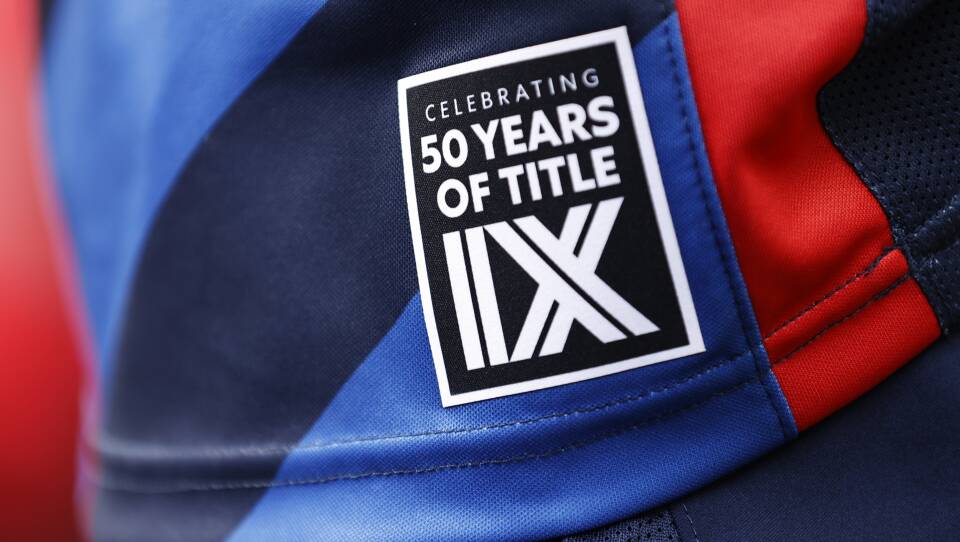 A black and white patch reading "celebrating 50 years of Title IX" is on a sports jersey