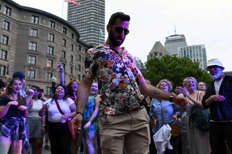 Crowd cheering on man dancing.