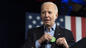 President Joe Biden puts on a button that was thrown to him from the crowd that says "Regulate Guns NOT Women" as he speaks at a campaign rally Saturday, March 9, 2024, at Pullman Yards in Atlanta.