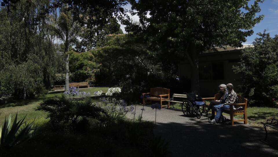 Larry Yarbroff visits his wife Mary at Chaparral House in Berkeley, Calif. in July. California health authorities had allowed some visits to resume, and now federal regulators are doing the same, with measures to try to block the spread of the coronavirus.