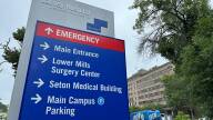 A sign points to various entrances of Carney Hospital.