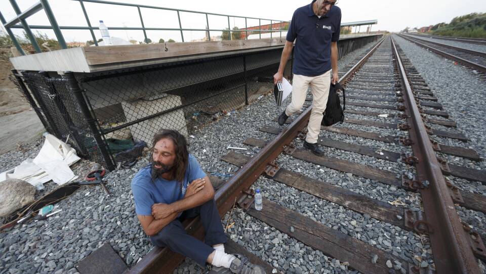 A man sits on train tracks