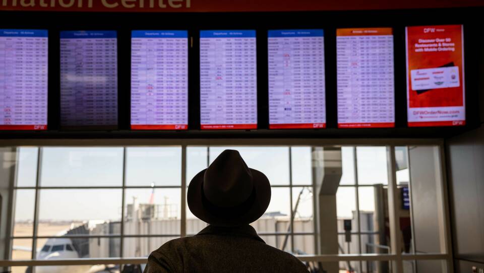 A passenger at Dallas-Fort Worth International Airport looks at a flight board after a system outage grounded thousands of flights throughout the country on Jan. 11.