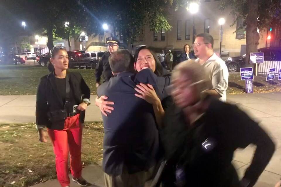 Michelle Wu beams while embracing someone.