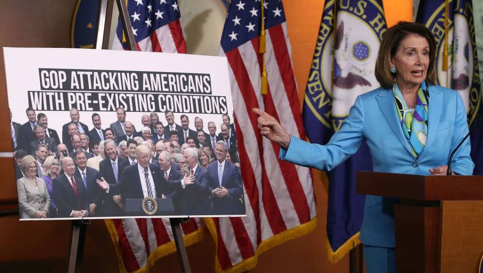 Democratic Minority Leader Nancy Pelosi, D-Calif., speaks about health care as she points to a picture of President Trump with House GOP members during her weekly press conference on Capitol Hill in June.