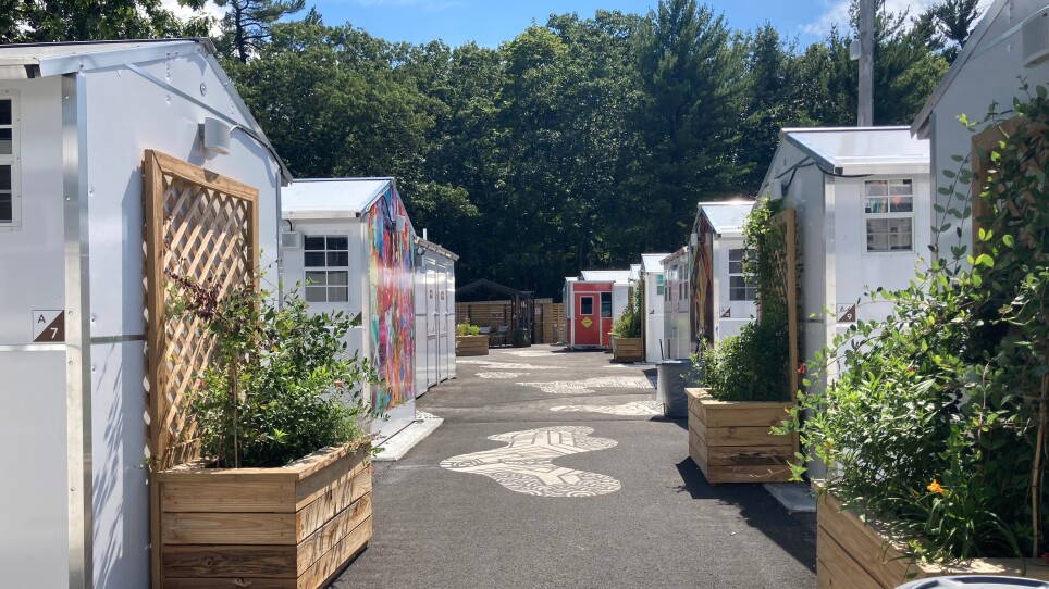 A path with small white cottages on either side.