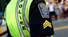 A close-up photo of a Boston Police officer wearing a neon vest over their uniform.