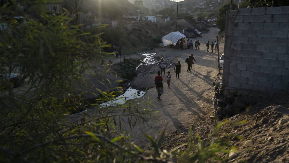 Afuera del albergue Embajadores de Jesús en Tijuana, personas planean y esperan una nueva vida por delante.