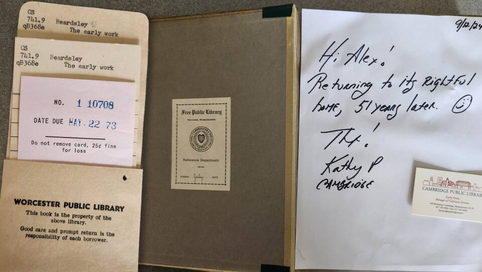 An old-fashioned library envelope and slip show a book due date of May 22, 1973. Next to it is a handwritten letter saying "Hi Alex! Returing to its rightful home, 51 years later" with a smiley face.