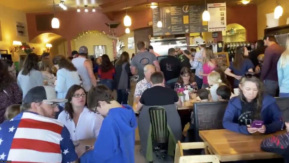A large crowd of people are seen at C&C Coffee and Kitchen in Castle Rock, Colo., celebrating Mother's Day as the restaurant opened its dining room in defiance of state orders.