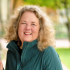 Middle aged white woman with blonde curly hair smiling