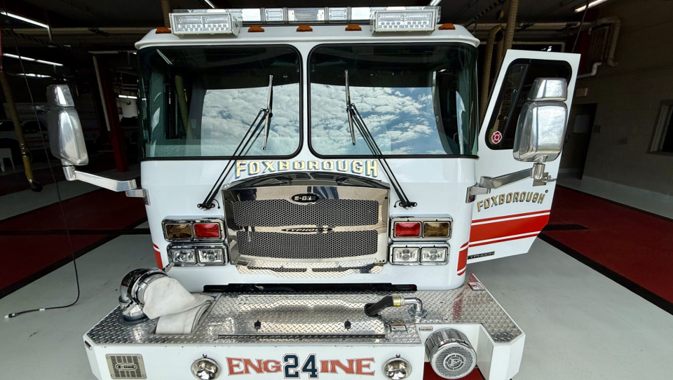 Front view of Foxborough Engine 24 fire truck parked inside garage bay.