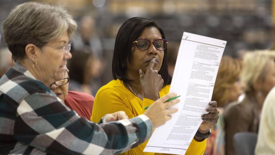Volunteers look at ballots during a hand recount in Palm Beach, Florida. The recount decided the election in favor of the Republican candidates for Senate and governor but election experts warn that similar problems could crop up again in 2020 if the state doesn't address them immediately.