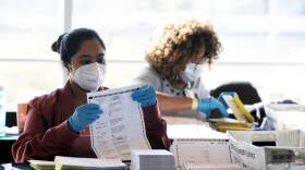 Election workers count Fulton County ballots at State Farm Arena on Nov. 4, 2020 in Atlanta. Falsehoods spread by former President Trump and his allies led to threats against election workers.