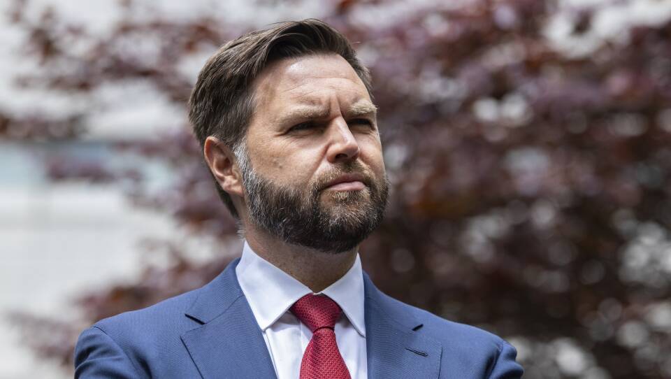 A bearded man in a suit and red tie