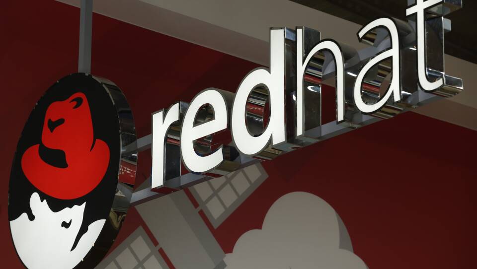 Tech giant IBM announced Sunday that it will acquire open source software company Red Hat. The company's logo is seen here at the Mobile World Congress in Barcelona, Spain, in February.