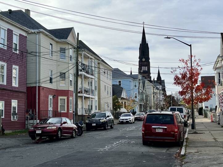 A westward view of Bullard Street in New Bedford, from the direction of Riverside Park, shows three-story apartment houses and St. Anthony of Padua Church.
