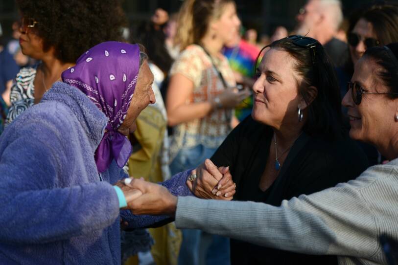 Three women holding hands and dancing.