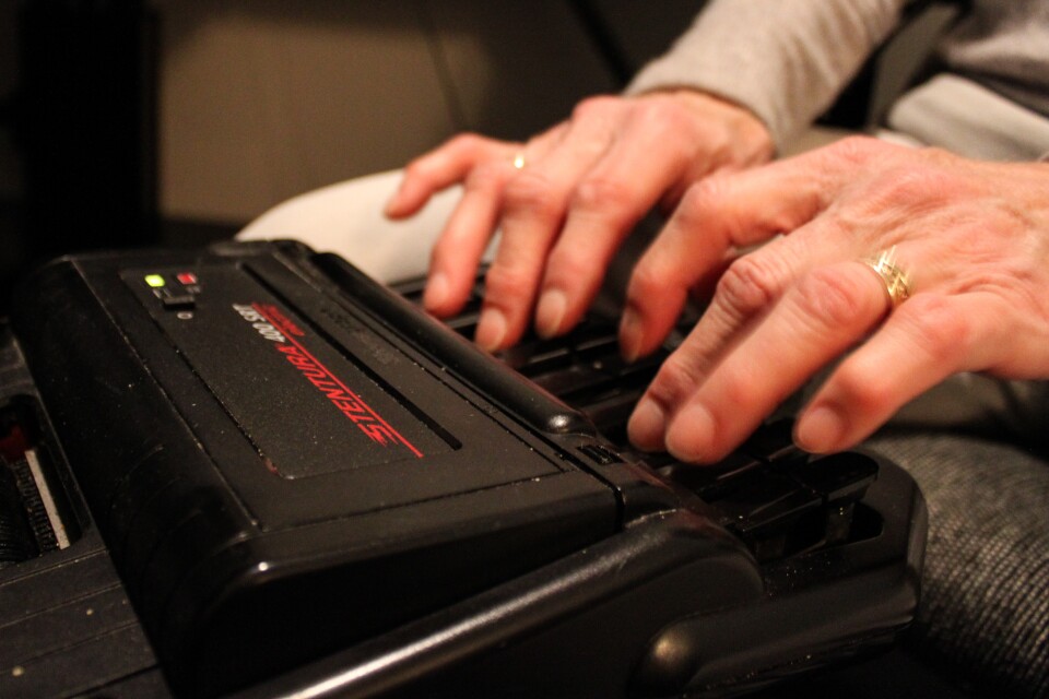 A stenographer uses a keyboard to provide closed captioning