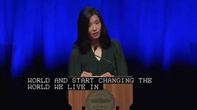 In an olive green blouse, the mayor speaks out from a podium emblazoned with Boston’s insignia. She’s standing in front of an illuminated blue curtain, looking intent mid-speech.