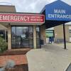 Signs reading "emergency admitting and registration" and "main entrance" mark the doors of a small hospital.