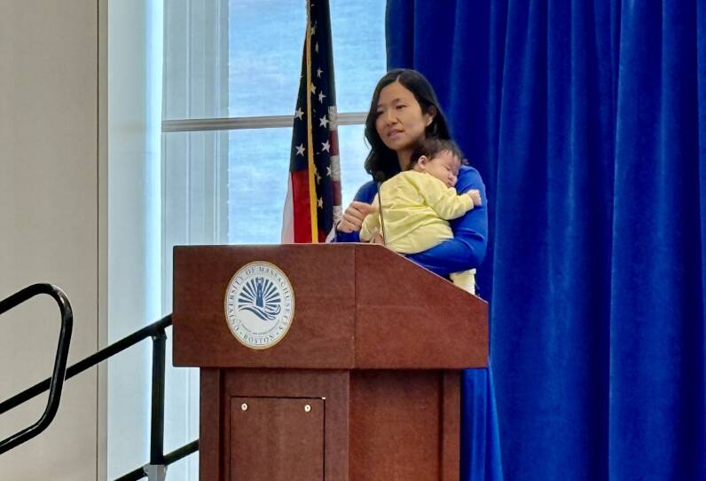 Boston Mayor holding her infant at podium while delivering remarks.